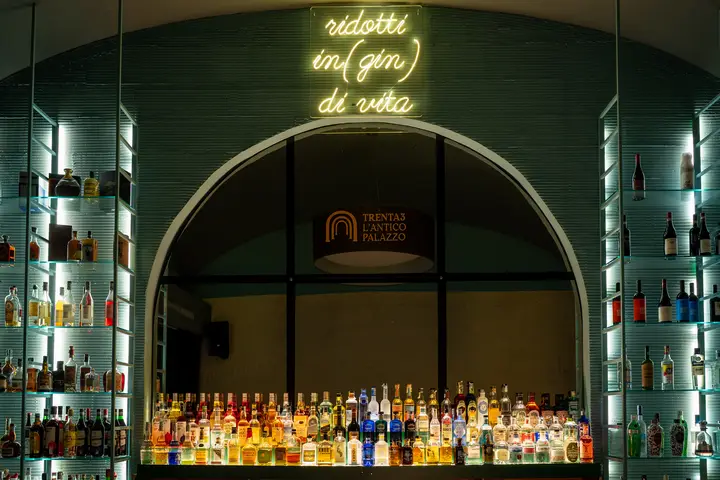 Il bar con l'insegna al neon e la bottigliera