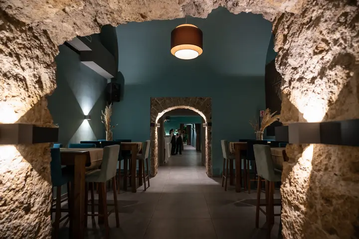 Sala in pietra con tavoli alti per l'aperitivo