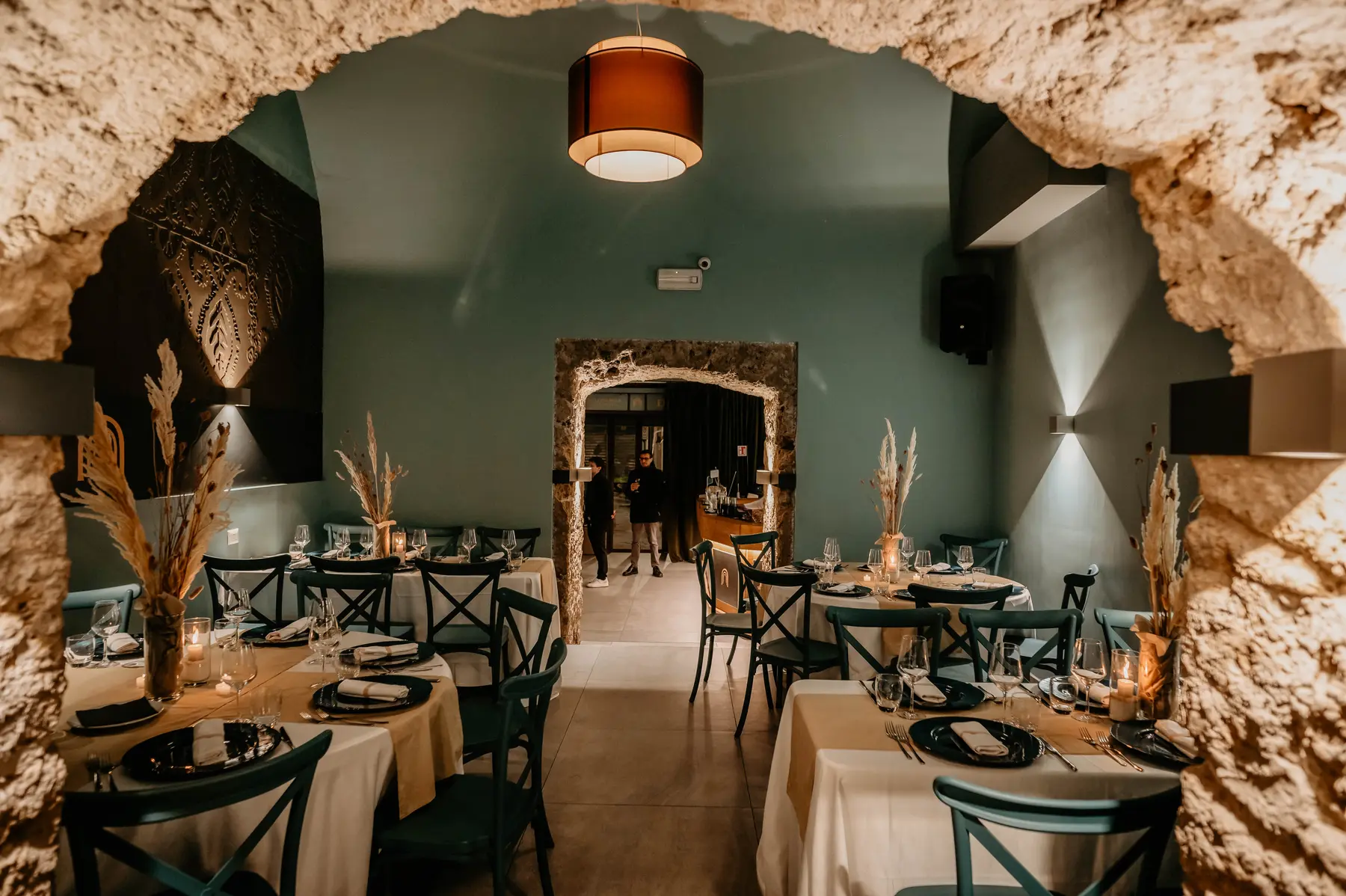 Sala con pareti in pietra a vista e tavoli apparecchiati