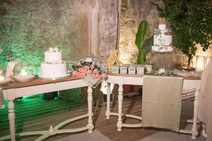 Tavolo della torta in giardino davanti al muro in pietra
